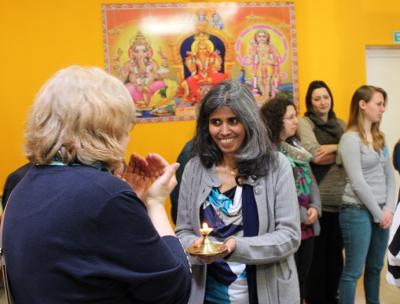 Rajiny Kumaraiah reicht Besucherinnen im Tempel das Licht der Butterlampe. (Foto: HdR/ Annedore Beelte-Altwig)